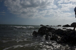 三亚海边礁石上的孤独身影