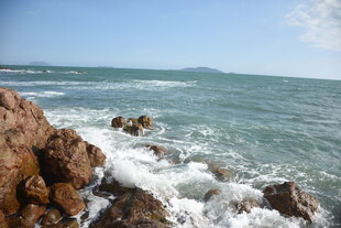 三亚海边礁石与翻涌海浪