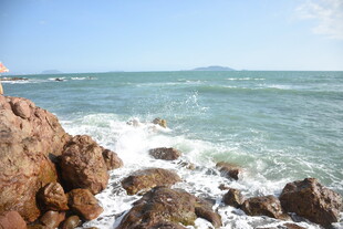 三亚海边礁石与翻涌海浪