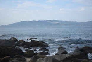 三亚海边礁石与远处山峦景色