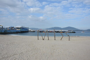 三亚海边沙滩与远处船只景观