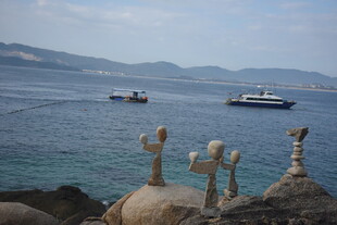 三亚海边独特雕塑与海上船只