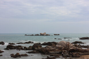 三亚海边岩石与远处孤石景观