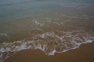 三亚海浪轻拍沙滩的美丽瞬间