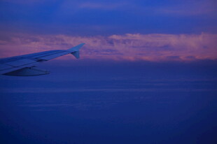 三亚黄昏下翱翔于天际的飞机