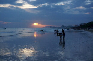 三亚夕阳下的海边漫步场景