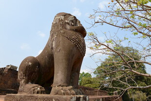 古老石狮子坐落在绿树间