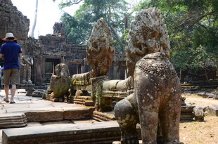 吴哥古迹前的游客与石像