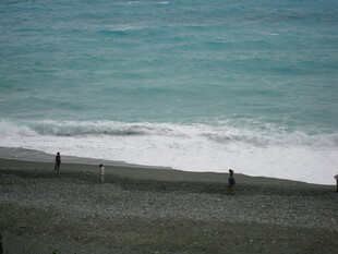 海边漫步的人群与海浪