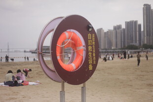 湛江沙滩上的救生圈与城市景观