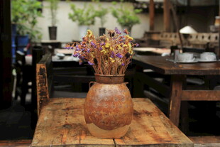 古朴陶罐插繁花于木桌