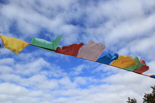 五彩经幡飘于蓝天白云间