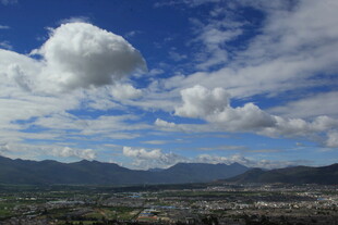 蓝天白云下的城市与远山