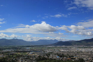 蓝天白云下的城市与远山