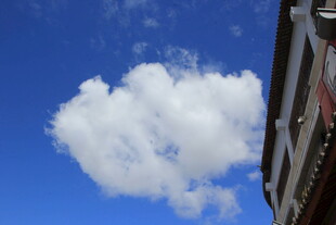 蓝天下的楼宇与蓬松云朵