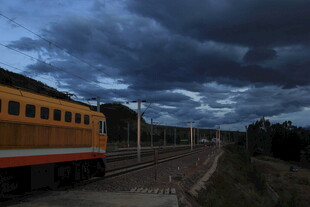 黄昏下铁轨旁的黄色列车