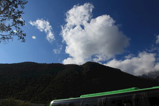 山间蓝天白云下的车辆