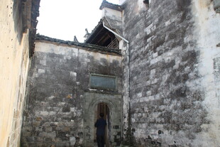 婺源古巷中的行人与斑驳老墙