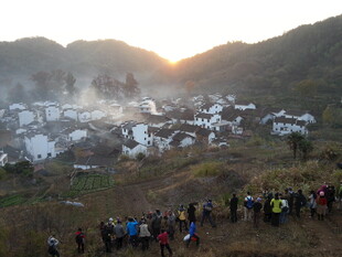 婺源山村晨曦下的徒步人群