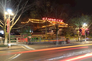 夜晚中式建筑旁的车流光影