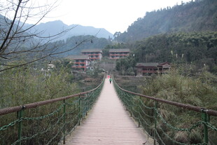 山间吊桥通向远处建筑