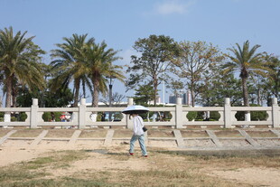 户外白栏杆旁漫步的人