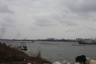 河畔船只与阴沉天空景象