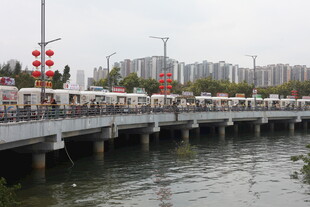 河畔桥上人群与中式装饰景观