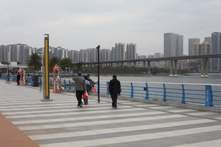 江边城市步道上的行人风景