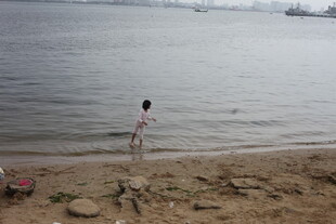 女孩于水边沙滩嬉戏