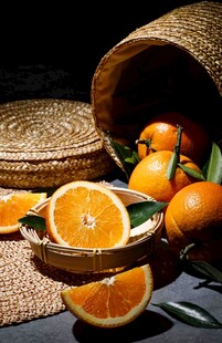 竹篮旁摆放的新鲜橙子