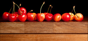 木桌上摆放的新鲜红樱桃