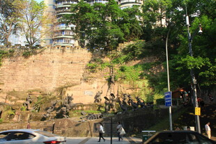 城市山坡旁的行人与车辆