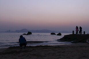 黄昏海边的静谧人物景象