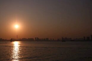 夕阳映水城市天际线