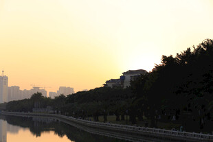 河畔夕阳下的城市静谧景象
