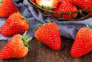 新鲜草莓摆放在木质桌面上