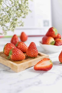 新鲜草莓摆放在木托盘上