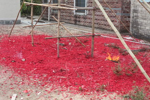 地上铺满燃放后的红鞭炮屑