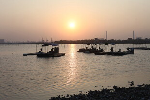 夕阳下的水上渔船景象