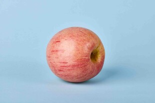 单个红苹果置于浅蓝色背景