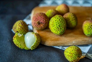 新鲜荔枝摆放在木砧板上