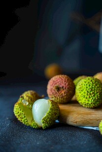 新鲜荔枝摆放在木砧板上