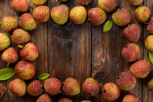 木桌上环绕摆放的新鲜荔枝