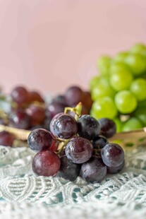 多彩葡萄摆于精致桌布上