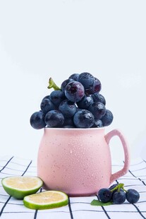 粉色杯装紫葡萄与青柠片