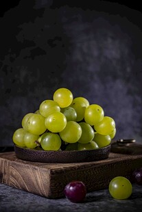 绿葡萄堆叠在木盘上