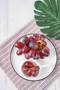 新鲜紫红葡萄摆于盘上