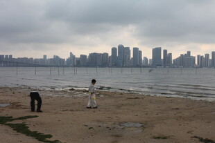 湛江海滨城市沙滩上的漫步身影