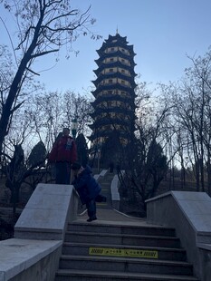 游客登台阶近观古塔